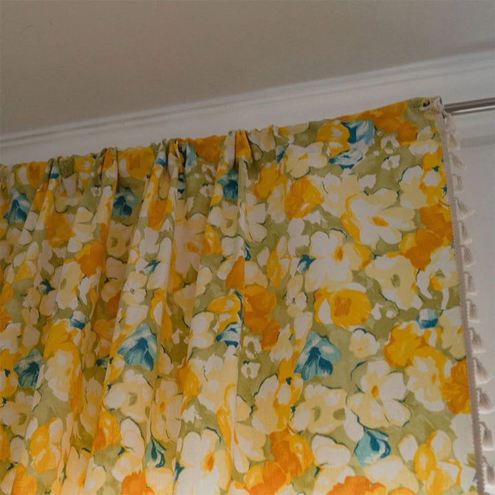 Halbverdunkelnder Vorhang mit gelbem Blumenmuster und Quasten