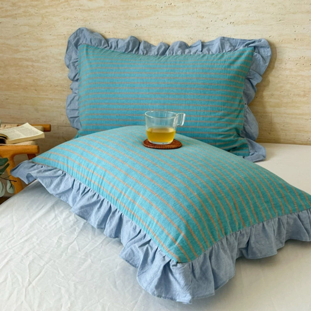 Housse de coussin à rayures et bord volanté