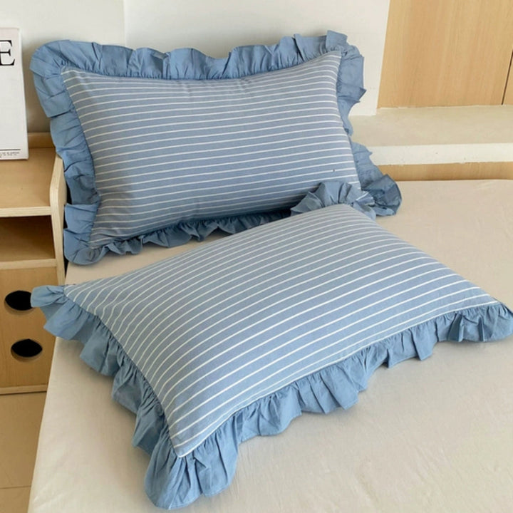 Housse de coussin à rayures et bord volanté