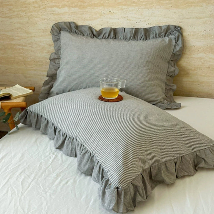 Housse de coussin à rayures et bord volanté
