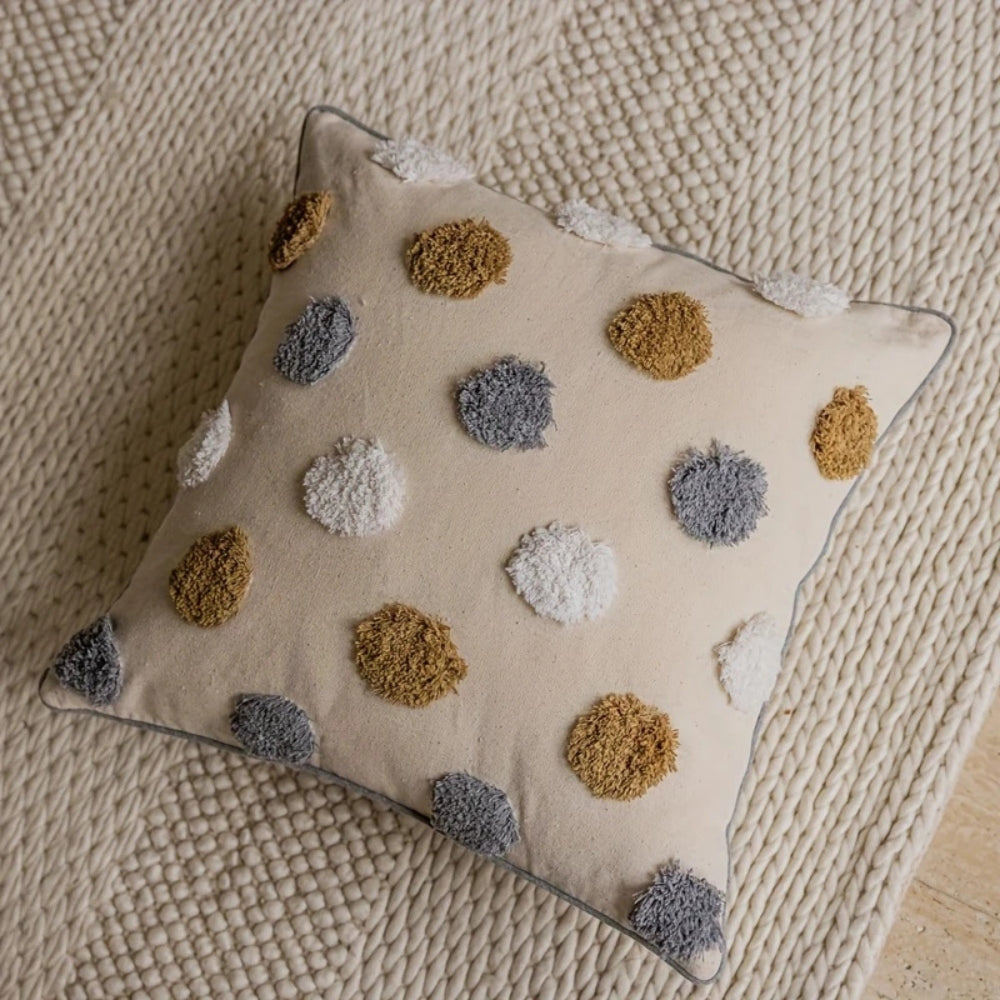 Housse de coussin à pois touffetés et passepoil