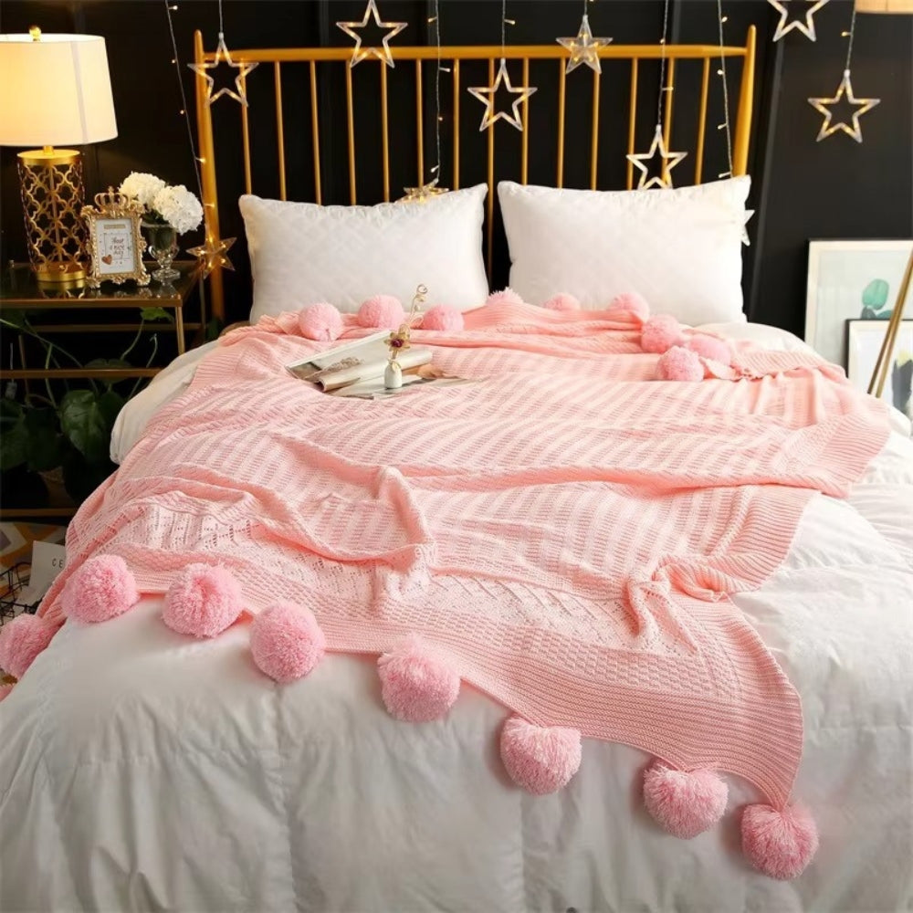 Gestrickte Decke mit Pompons